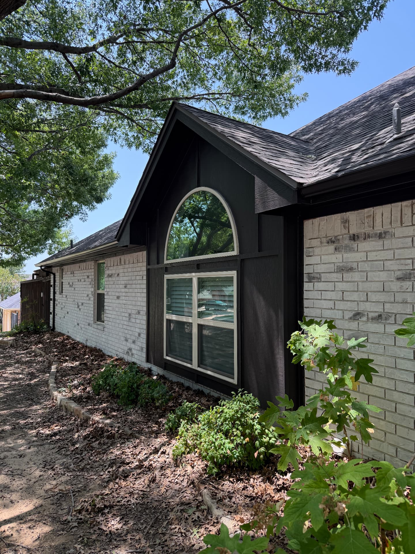 Gable siding repainted charcoal with crisp white window trim