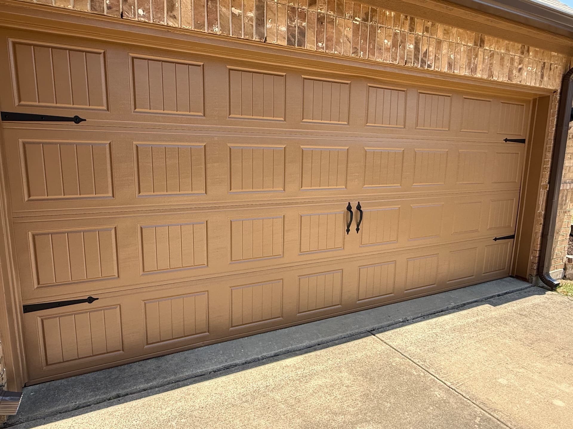 Freshly repainted garage door with clean black hardware